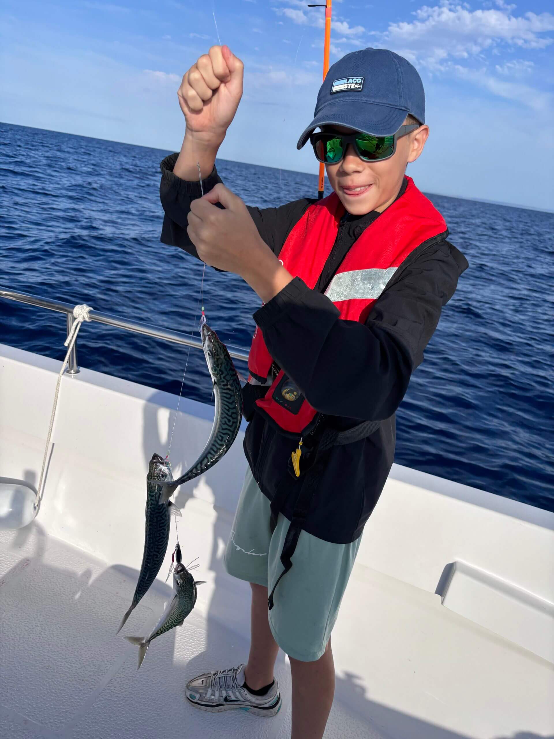 Jeune pêcheur fier de remonter plusieurs maquereaux lors d’une sortie pêche en famille à Port-Camargue Jeune pêcheur fier de remonter plusieurs maquereaux lors d’une sortie pêche en famille à Port-Camargue